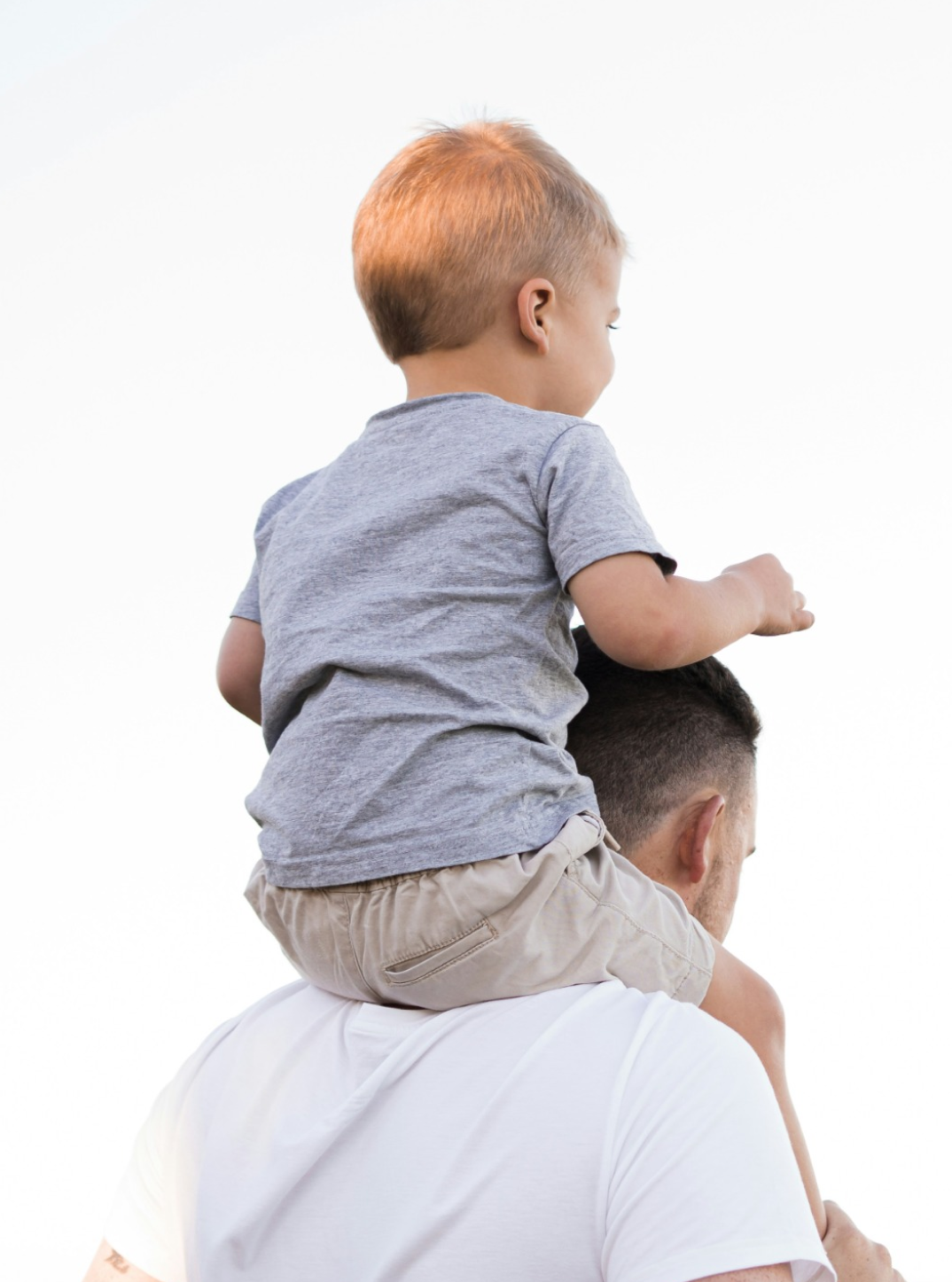 a man carrying a kid on his shoulders